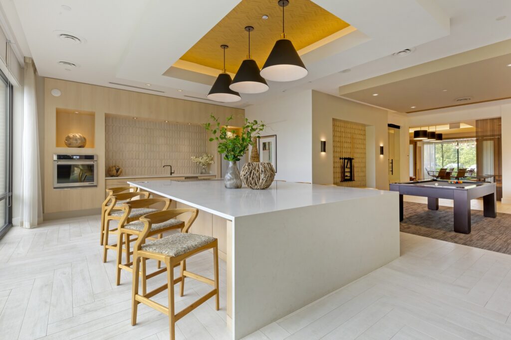 Clubhouse with bar seating, kitchen area, pool table and designer lighting