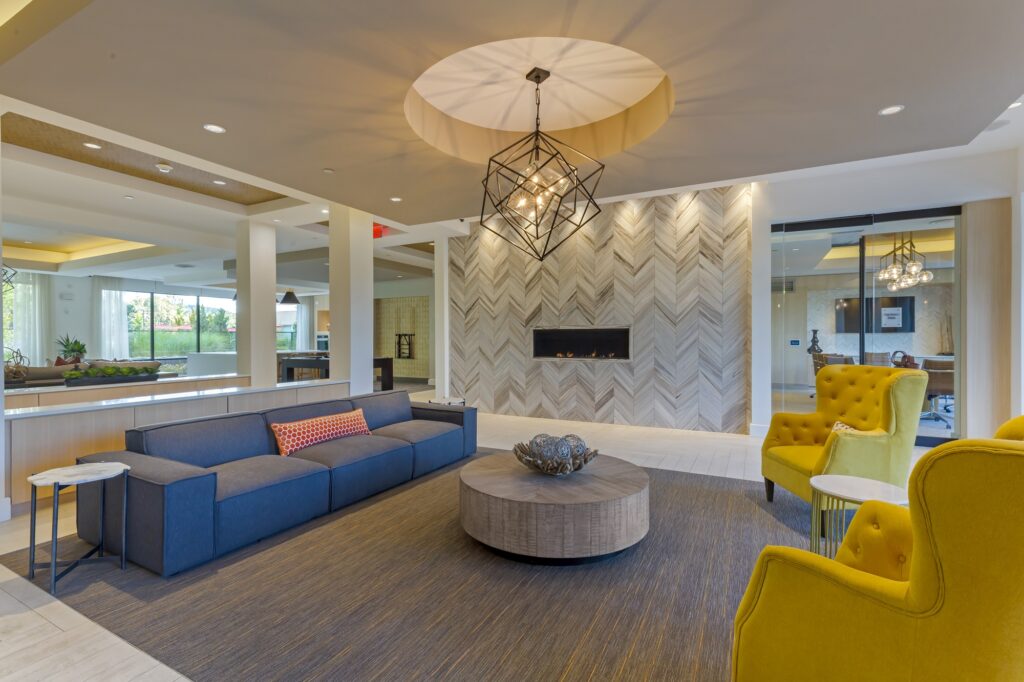 Clubhouse with variety of modern seating, fireplace, designer lighting, and tile flooring