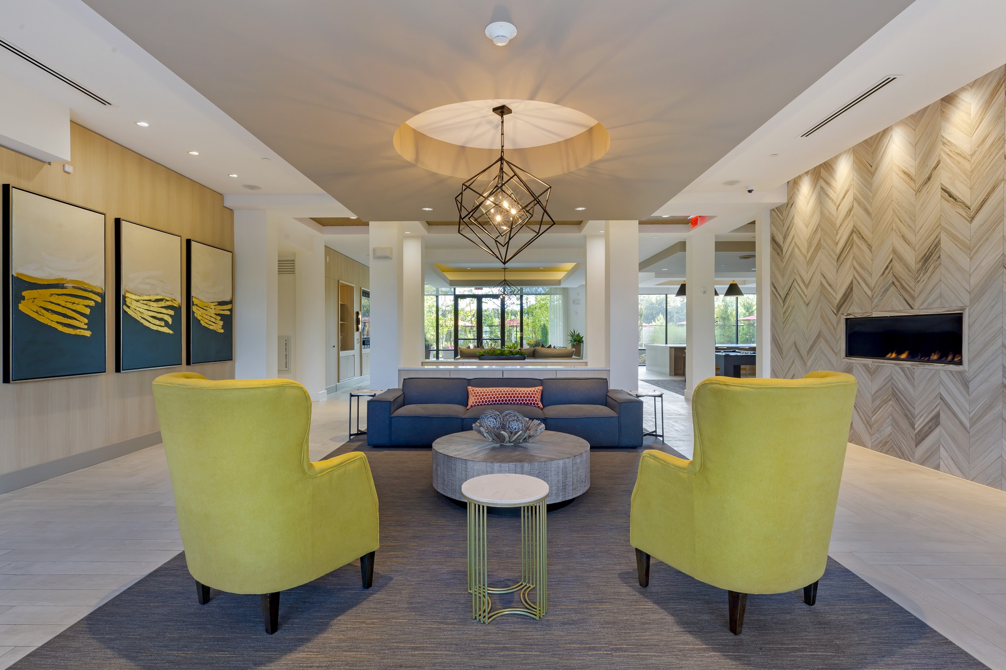 Clubhouse with variety of modern seating, fireplace, designer lighting, and tile flooring