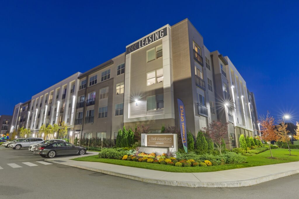 Exterior dusk shot of entrance to apartment complex with garden landscaping