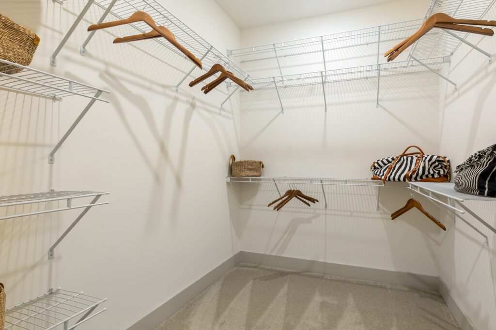 Empty and open walk in-closet with clothes hangers and racks to hang clothes