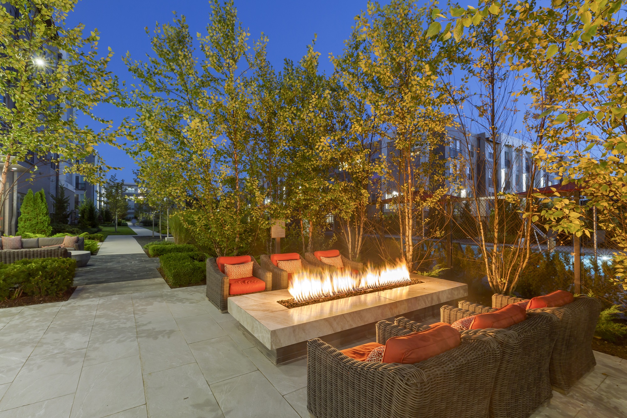 Dusk shot showing outdoor seating by the swimming pool and fire pit