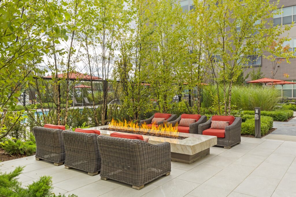 Afternoon shot showing outdoor seating by the swimming pool with fire pit