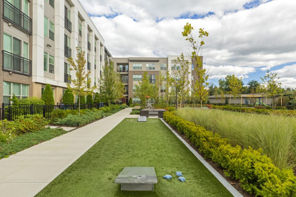 Outdoor play area with cornhole game and garden landscaping