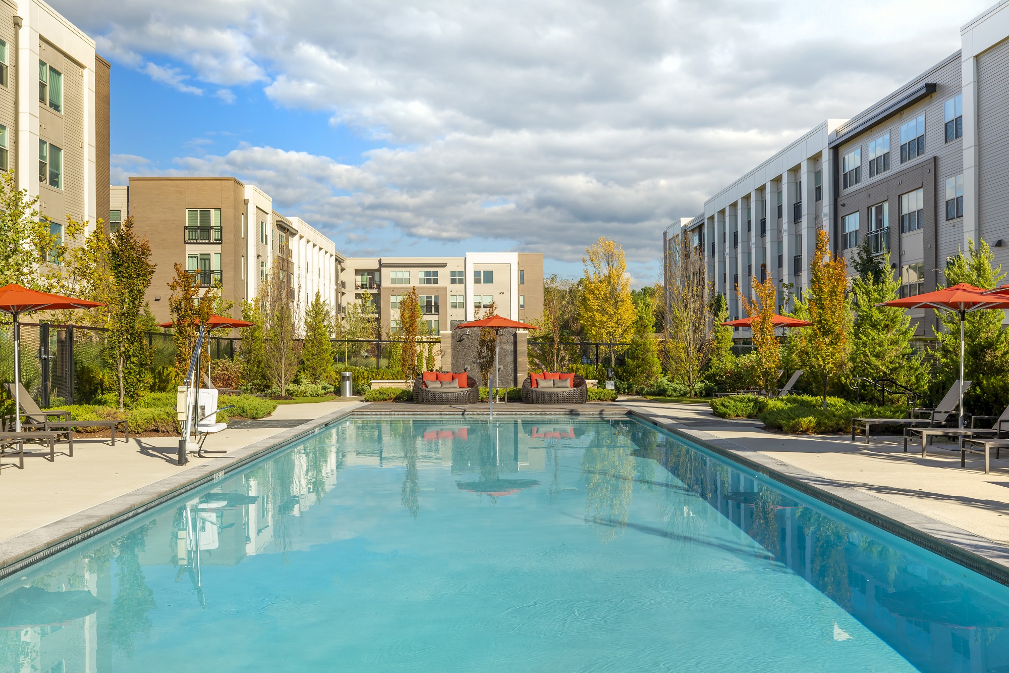 Afternoon shot of courtyard swimming pool with lounge seating and umbrellas